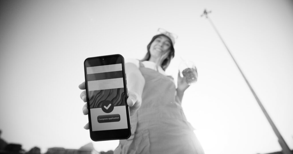 Vrouw met telefoon die op een gebruiksvriendelijke manier haar online actie heeft kunnen afronden.